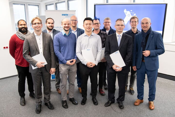 Elf Personen stehen in der Sylounge auf dem Hauptgebäude der RWTH und schauen in die Kamera.