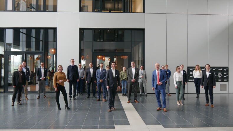 Das Bild zeigt Teilnehmende des Kick-Off Workshop zum Konsortial-Benchmarking „Circular Economy – Lifecycle-Management in produzierenden Unternehmen“. Zwanzig Personen stehen mit Abstand zueinander in einer Eingangshalle.